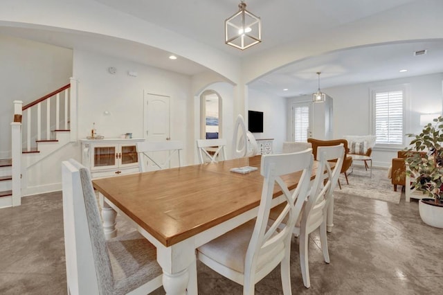 dining area featuring visible vents, baseboards, stairs, recessed lighting, and arched walkways