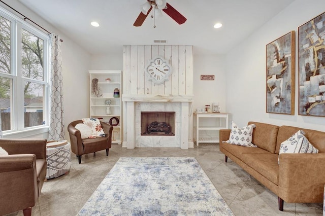 living area featuring a fireplace, visible vents, ceiling fan, and recessed lighting
