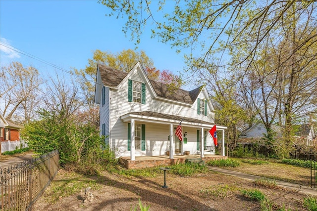 view of front of property featuring fence and a porch