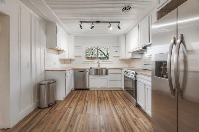 kitchen featuring a sink, open shelves, butcher block countertops, stainless steel appliances, and visible vents