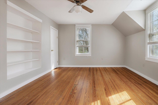 bonus room with baseboards, hardwood / wood-style flooring, and a healthy amount of sunlight