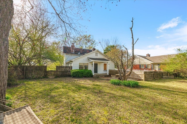 back of house with a yard, a chimney, and fence private yard