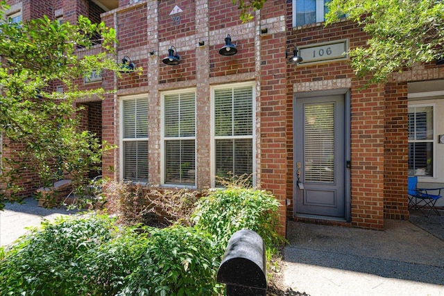 entrance to property featuring brick siding