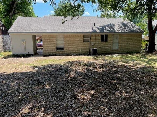 rear view of property featuring cooling unit and brick siding