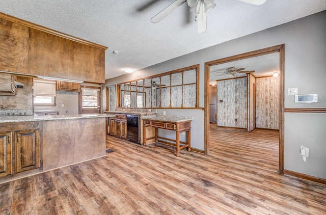 kitchen with light wood-type flooring, light countertops, ceiling fan, and a textured ceiling
