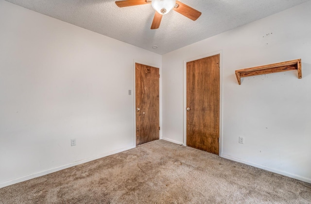 unfurnished bedroom featuring carpet flooring, a ceiling fan, baseboards, and a textured ceiling