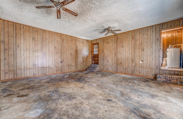 empty room featuring water heater, a textured ceiling, and ceiling fan