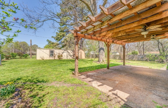 view of yard with fence, an outbuilding, a patio, and a ceiling fan