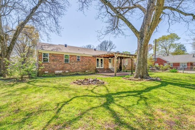 rear view of property with crawl space, brick siding, a pergola, a yard, and a patio area