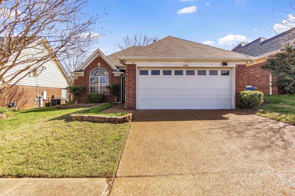 1538 Beringer Dr, Cordova, TN 38018 - single story home featuring driveway, central air condition unit, brick siding, a front lawn, and a garage