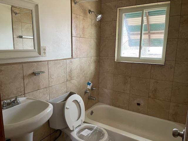 3291 Lockmeade Dr, Memphis, TN 38127 - bathroom featuring tile walls, shower / tub combination, a sink, and toilet