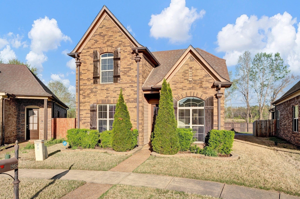 traditional-style house with brick siding and fence
