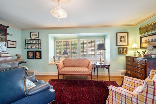 living room with visible vents, crown molding, baseboards, and wood finished floors