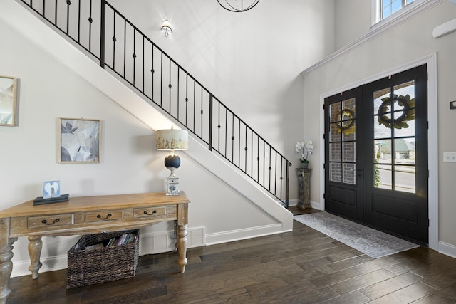 entryway with stairs, a high ceiling, wood finished floors, and baseboards