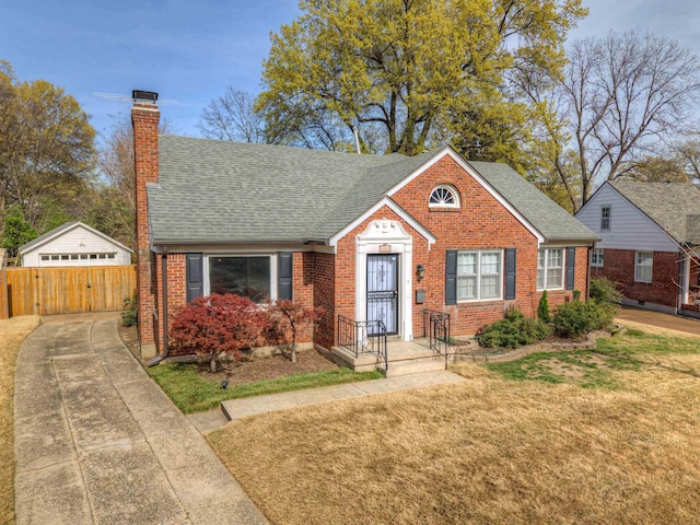26 N Ashlawn Dr, Memphis, TN 38112 - bungalow-style home with brick siding, a shingled roof, a front lawn, and a chimney