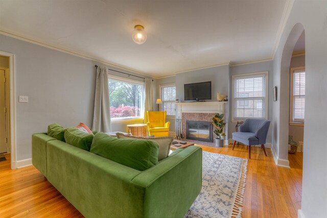26 N Ashlawn Dr, Memphis, TN 38112 - living area with a fireplace with flush hearth, light wood-style flooring, baseboards, arched walkways, and ornamental molding