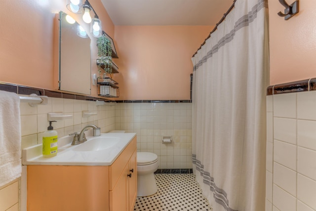 26 N Ashlawn Dr, Memphis, TN 38112 - bathroom featuring tile walls, wainscoting, toilet, and vanity