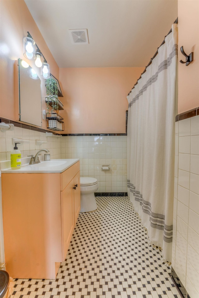 26 N Ashlawn Dr, Memphis, TN 38112 - full bath with toilet, vanity, wainscoting, visible vents, and tile walls