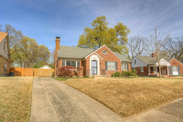 26 N Ashlawn Dr, Memphis, TN 38112 - bungalow-style house with brick siding, a front lawn, fence, and a chimney