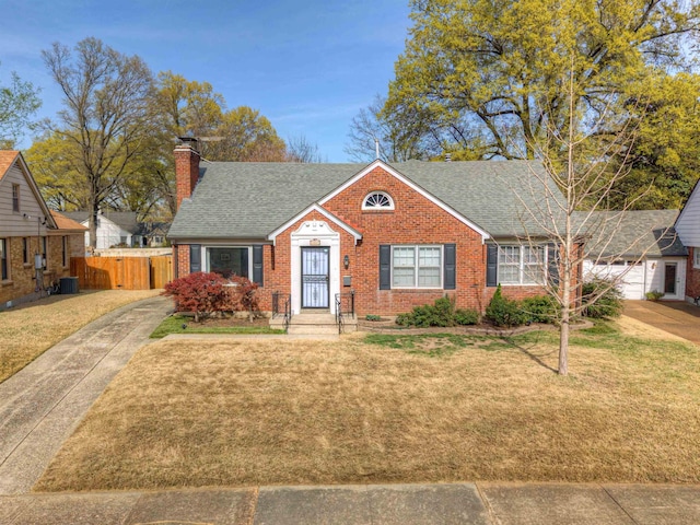 26 N Ashlawn Dr, Memphis, TN 38112 - bungalow with brick siding, central air condition unit, a front yard, and roof with shingles