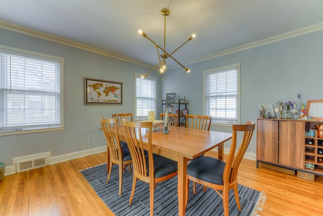 26 N Ashlawn Dr, Memphis, TN 38112 - dining area with visible vents, crown molding, baseboards, light wood-type flooring, and a notable chandelier