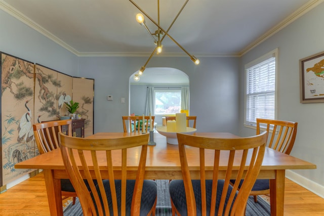 26 N Ashlawn Dr, Memphis, TN 38112 - dining space with arched walkways, crown molding, baseboards, and light wood finished floors