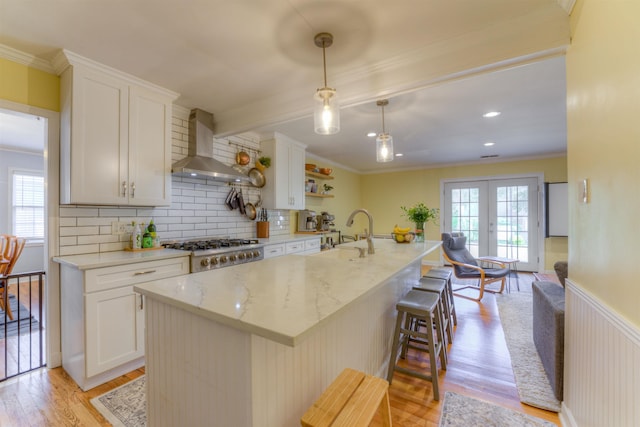 26 N Ashlawn Dr, Memphis, TN 38112 - kitchen featuring a wealth of natural light, crown molding, a sink, light wood finished floors, and wall chimney exhaust hood