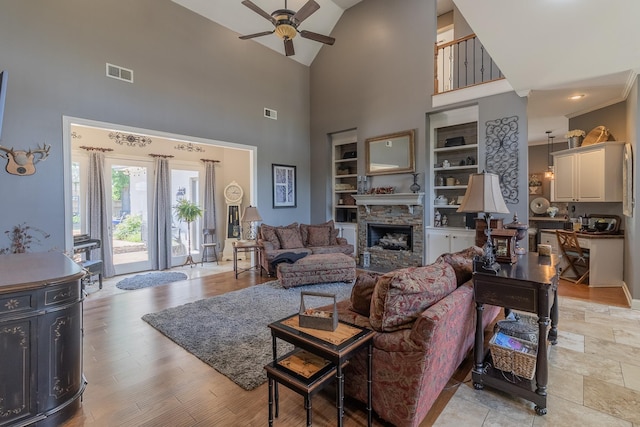 1249 Mintmere Dr, Collierville, TN 38017 - living area featuring a ceiling fan, high vaulted ceiling, built in features, a stone fireplace, and light wood-style flooring