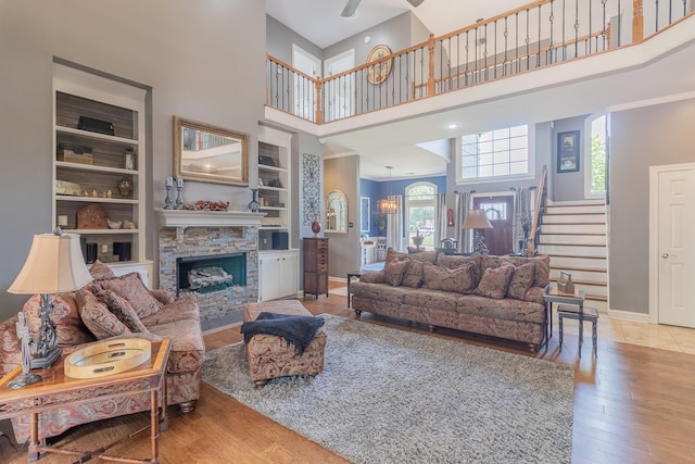 1249 Mintmere Dr, Collierville, TN 38017 - living area with a high ceiling, a fireplace, stairs, wood finished floors, and a ceiling fan