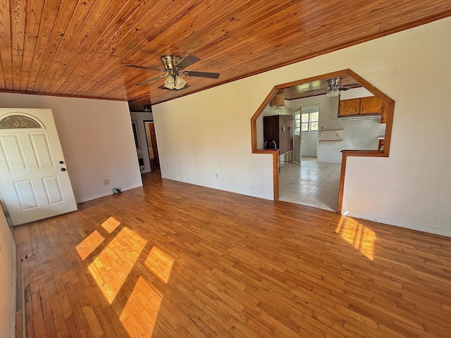 unfurnished living room with a ceiling fan, wood ceiling, arched walkways, and wood finished floors