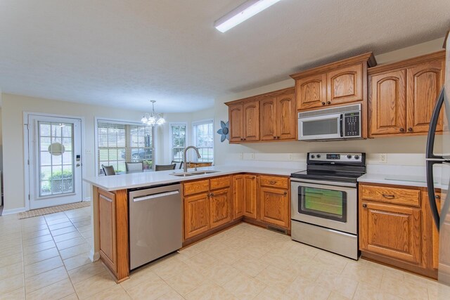 145 Ping Hill Cv, Counce, TN 38326 - kitchen with an inviting chandelier, brown cabinetry, a sink, and stainless steel appliances