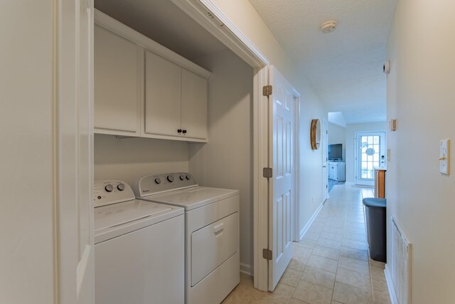 145 Ping Hill Cv, Counce, TN 38326 - laundry area with light tile patterned floors, baseboards, visible vents, cabinet space, and washer and dryer