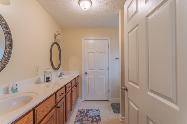 145 Ping Hill Cv, Counce, TN 38326 - full bathroom featuring tile patterned floors, double vanity, a sink, and a textured ceiling