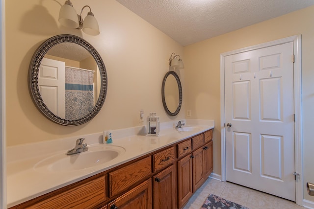 145 Ping Hill Cv, Counce, TN 38326 - bathroom with tile patterned floors, a sink, double vanity, and a textured ceiling