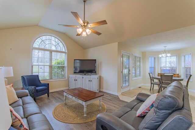 145 Ping Hill Cv, Counce, TN 38326 - living room with ceiling fan with notable chandelier, baseboards, vaulted ceiling, and wood finished floors