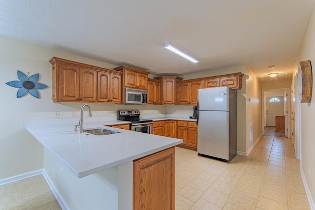 145 Ping Hill Cv, Counce, TN 38326 - kitchen with light countertops, a peninsula, brown cabinets, appliances with stainless steel finishes, and a sink
