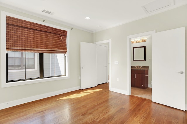 358 N Island Dr Unit 105, Memphis, TN 38103 - unfurnished bedroom featuring visible vents, baseboards, wood finished floors, attic access, and a sink