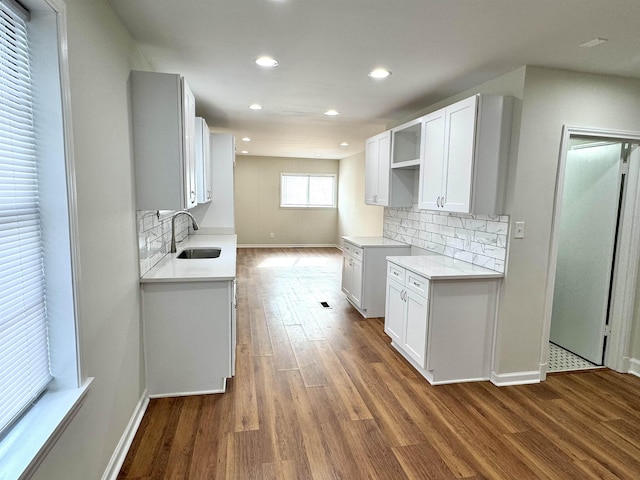 1280 Salem St, Memphis, TN 38122 - kitchen featuring a sink, backsplash, baseboards, and dark wood-style floors
