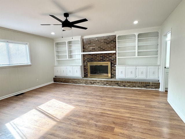 1280 Salem St, Memphis, TN 38122 - unfurnished living room featuring baseboards, built in shelves, a brick fireplace, ceiling fan, and wood finished floors