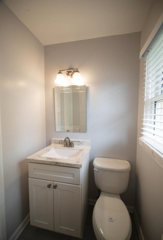 bathroom with vanity, baseboards, and toilet