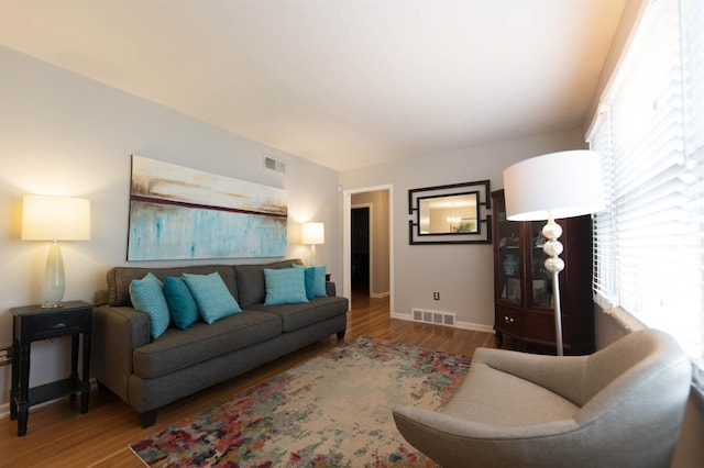 living area with wood finished floors, visible vents, and a wealth of natural light