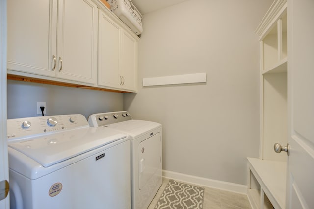 laundry room with washer and dryer, baseboards, and cabinet space