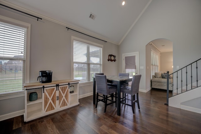 dining area featuring crown molding, dark wood-type flooring, arched walkways, visible vents, and baseboards