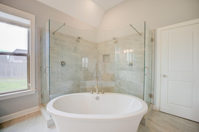 bathroom with a soaking tub, a stall shower, vaulted ceiling, and tile patterned flooring