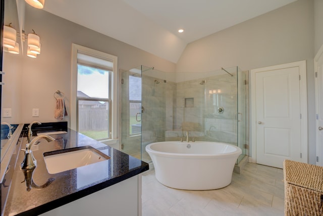 full bath featuring a stall shower, a freestanding tub, vanity, and lofted ceiling