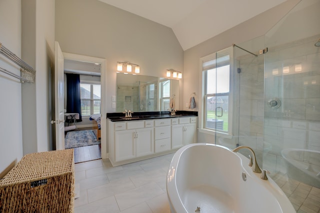 bathroom with double vanity, a soaking tub, a shower stall, lofted ceiling, and a sink