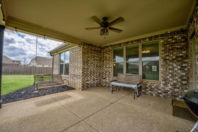 view of patio with fence and a ceiling fan