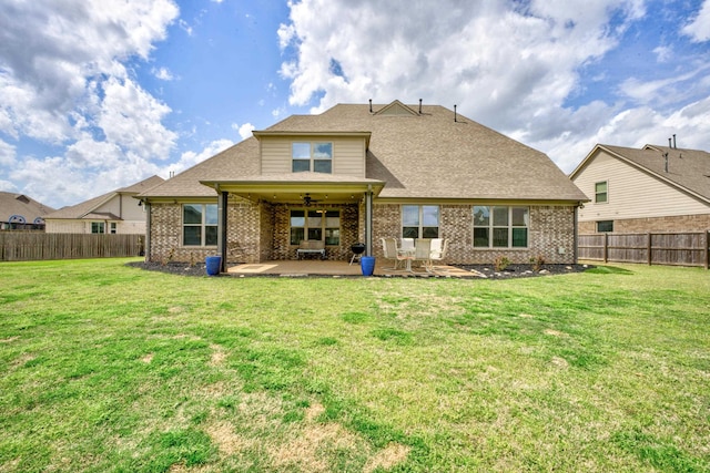 rear view of property with brick siding, a patio area, a fenced backyard, and a lawn