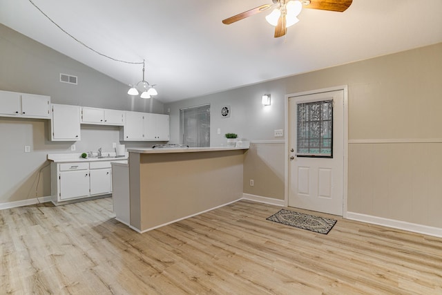 3562 Pueblo Ave, Memphis, TN 38127 - kitchen featuring vaulted ceiling, a peninsula, white cabinetry, ceiling fan, and light wood finished floors