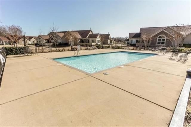pool featuring a patio, a residential view, and fence